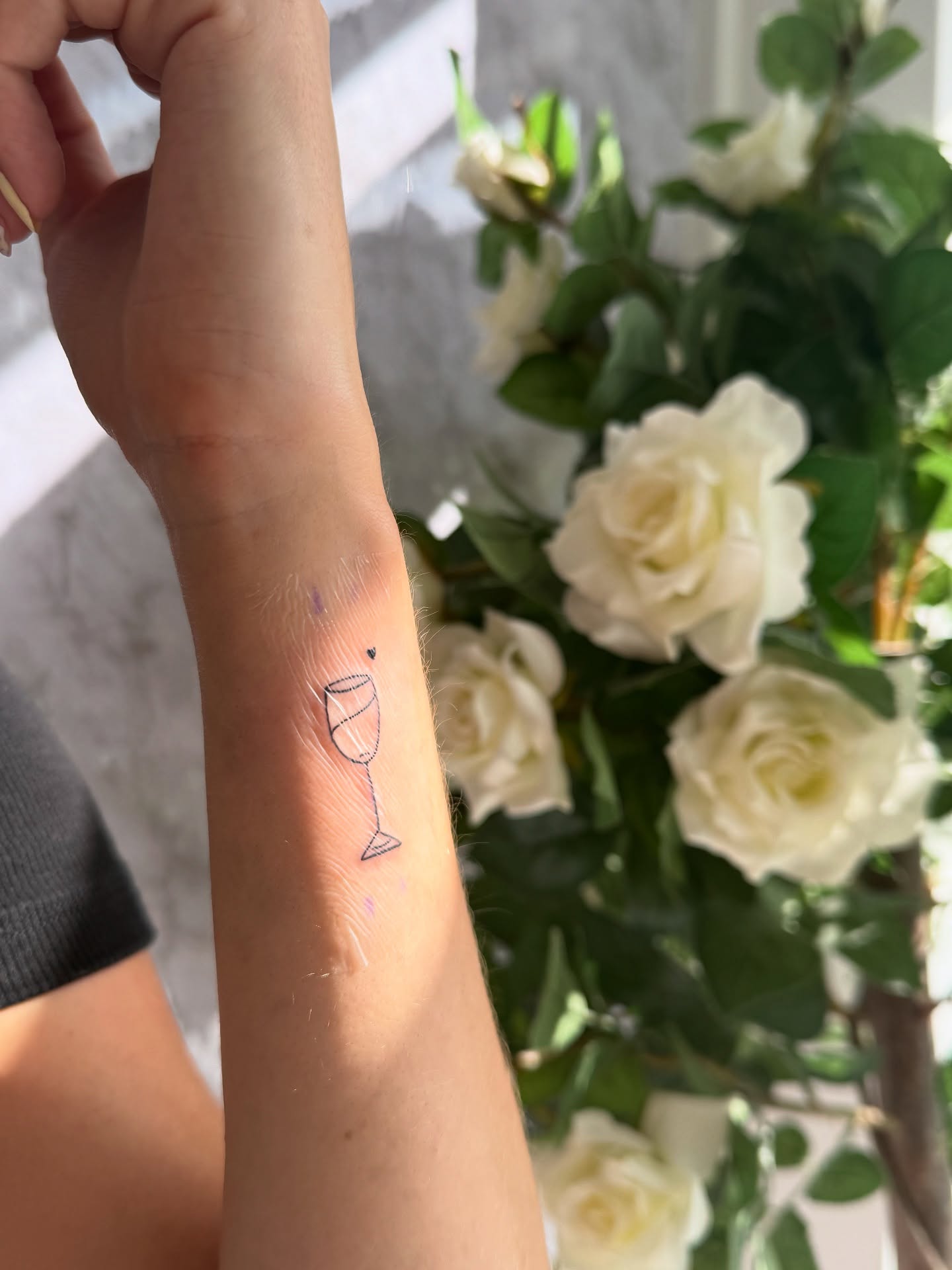 Fine-line wine-glass tattoo result